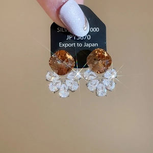 Detailed close-up of geometric silver earrings with champagne square stone and zircons