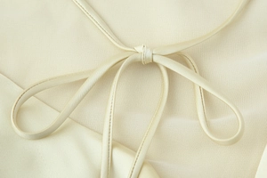 Detailed macro view of the silky satin fabric texture and elegant halter neck tie knot