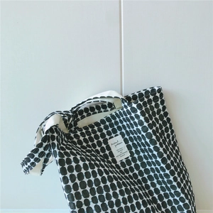 Detail of geometric dot pattern on cotton tote bag with a minimalist woven label