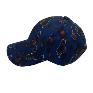 Gedetailleerd zijaanzicht van donkerblauwe baseballpet met luipaardprint en gouden lijnen