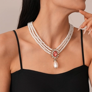Detail of three-layer pearl necklace with a vintage ruby floral pendant and water drop pearl
