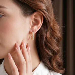 Elegant gold hoop earring with pavé square cubic zirconia on a model's ear