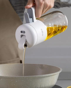 Gros plan d'un flacon d'huile en verre de 500ml versant de l'huile dans une poêle