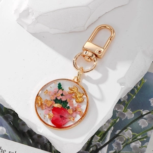 Handmade resin goldfish keychain with pink dried flowers and gold foil accents