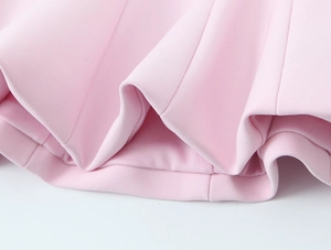 Detailed close-up of the pink ruffled hemline showing fine knit fabric texture