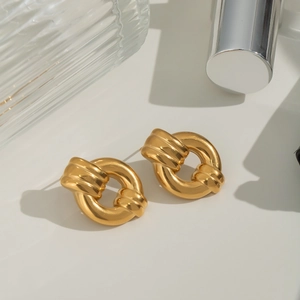 Detail of gold knot earrings in waterproof titanium steel on a clean white surface