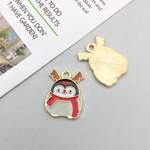 Detail of Christmas penguin enamel pendant showing gold-plated back and front design