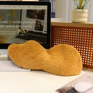 Creative peanut-shaped plush pillow cushion placed on a cozy office desk setup