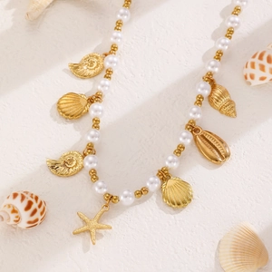 Detailansicht der Boho-Meereshalskette mit weißen Perlen, goldenen Seesternen und Muscheln