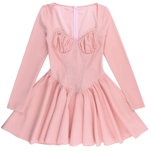 Close-up of pink long sleeve dress featuring lace trim and ruffled flared skirt details