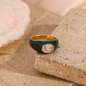 Detail of vintage 18K gold plated ring with green enamel and oval cubic zirconia