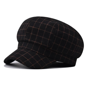 Detailed close-up of newsboy cap featuring black and brown plaid pattern wool fabric