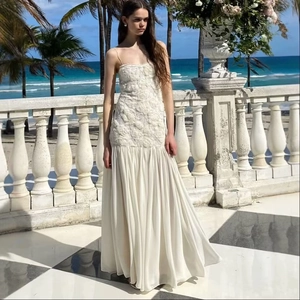 Elegante abito lungo bianco in pizzo floreale con gonna a pieghe per le vacanze