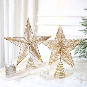 Close-up of golden glitter star tree topper with warm LED lights and elegant metal weave