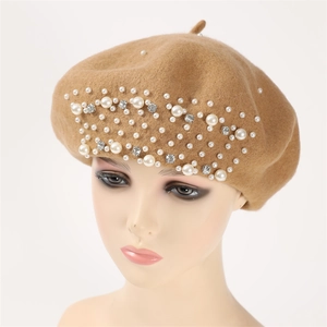 Close-up of elegant camel cashmere beret with hand-sewn pearls and sparkling rhinestones