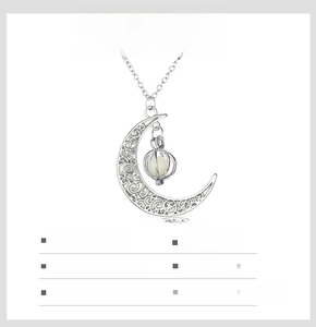 Luminous crescent moon necklace detail showing silver alloy cage and scrollwork design
