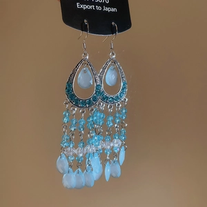 Detail of bohemian silver leaf earrings with blue beads, rhinestones and elegant tassels