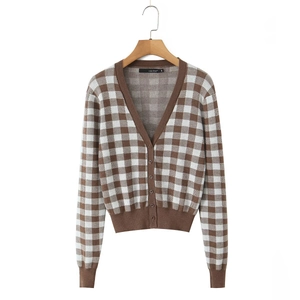 Close-up of the V-neckline and button-down front of a checkered knit cardigan with a brand label
