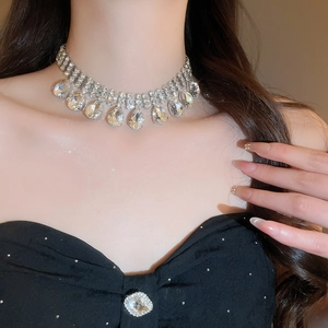 Macro detail of luxury teardrop rhinestone necklace featuring silver tiered crystal tassels