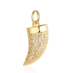 Golden horn pendant with shimmering cubic zirconia stones on white background