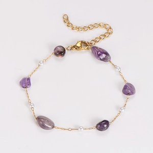 Detail of gold chain bracelet with irregular amethyst stones and white pearls