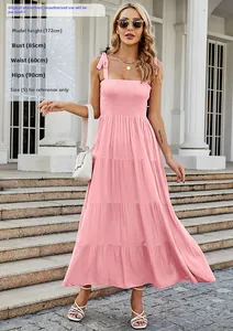 Detail of pink smocked bodice and tiered maxi dress layers on model outdoors