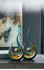 Detail of dark green ceramic sculpture with hand-painted gold edges and golden orb