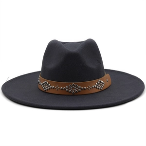 Close-up of wide brim fedora hat with brown leather band and silver metal rivets