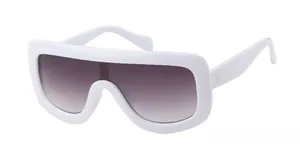 Close-up of oversized white frame aviator sunglasses with gold dot studs and gradient lens