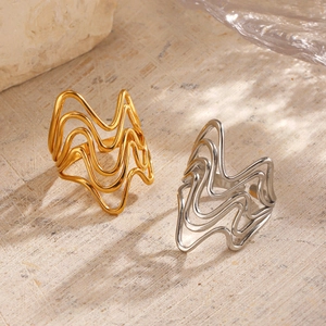 Minimalist 18K gold and silver plated irregular wave rings on aesthetic stone display