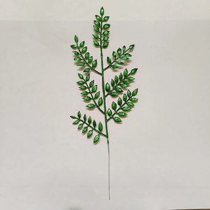 Dettaglio del ramo con foglie artificiali verdi e glitter per decorazioni natalizie