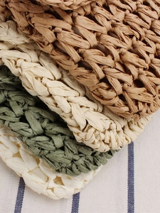 Handmade woven beach bag in brown, beige, and olive green with natural fiber texture