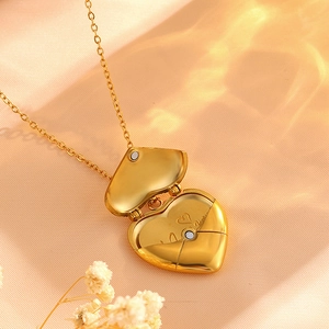 Detail of golden heart locket with internal floral engraving on warm satin background