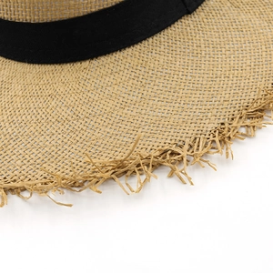 Détail du tressage en paille naturelle et bord effiloché du chapeau de paille