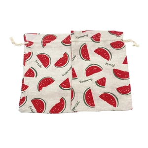 Detail of two cotton drawstring bags with fresh red watermelon prints and cream ropes