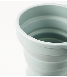 Close-up of a light blue foldable silicone travel cup showing tiered expansion structure