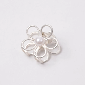 Close-up of silver metal flower hair claw clip with a central pearl inlay detail