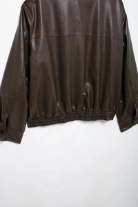 Detalle del dobladillo y puños elásticos de la chaqueta de cuero marrón oscuro