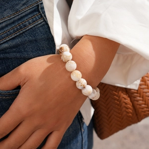 Close-up of a white marble texture beaded bracelet worn by a model in casual attire