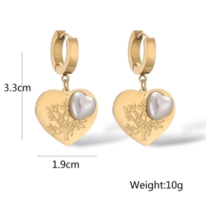 Macro view of gold heart earrings with tree of life engraving and pearl, 3.3cm size