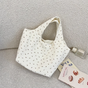 Vue détaillée du sac cabas en velours côtelé à fleurs brunes sur fond de tissu crème