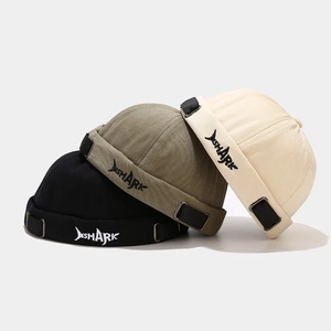 Detail of shark embroidery on canvas miki hats in black, olive green, and beige