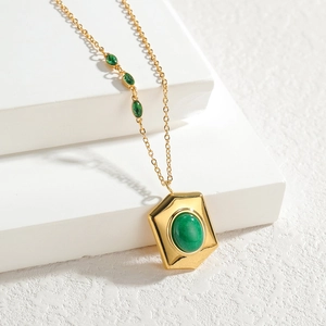 Collier en or minimaliste avec pendentif hexagone et pierres vertes sur fond blanc
