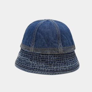 Detailed view of blue denim bucket hat featuring contrast yellow stitching and textured fabric