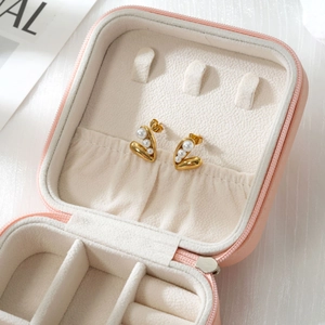 Nahaufnahme der herzförmigen 18k Gold Perlenohrringe in einer rosa Schmuckbox