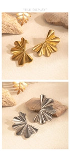 Detailed view of striped fan-shaped stud earrings in polished gold and silver finishes