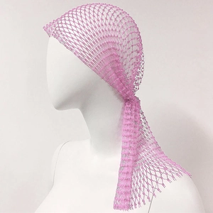 Detailed close-up of pink beaded mesh headpiece with crystal embellishments on a mannequin