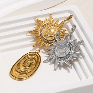 Close-up of 18K gold and silver celestial pendants with moon, sun and small crystals