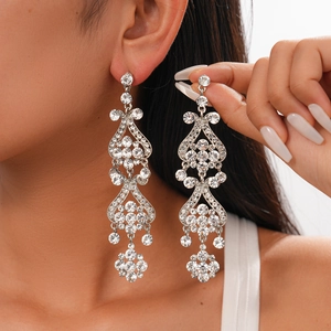 Close-up of floral tassel earrings with sparkling rhinestones worn by a model