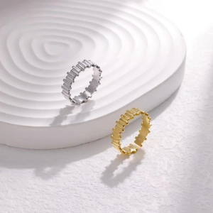 Macro view of gold and silver stainless steel rings with gear texture on ripple tray